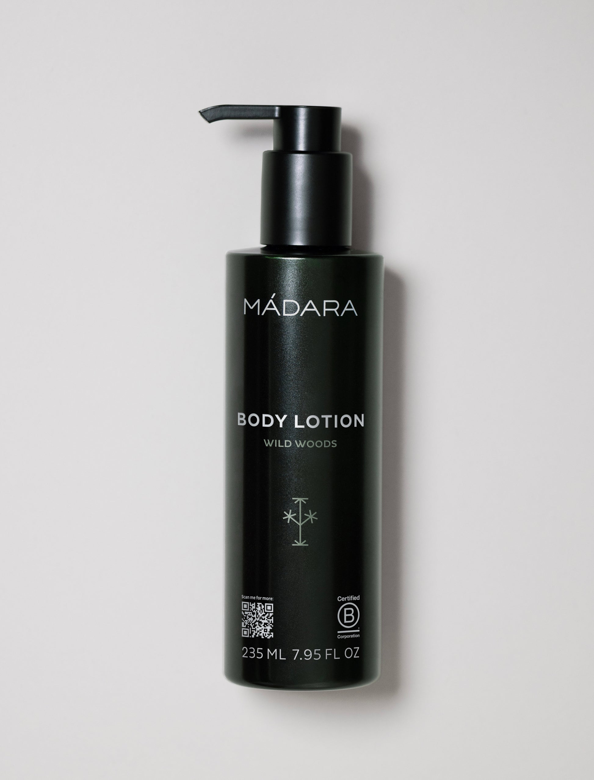 Black bottle of Mádara body lotion on a light gray background