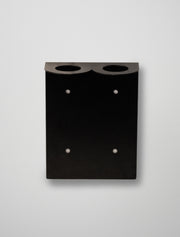 Black soap stend with two circular holes on a light gray background